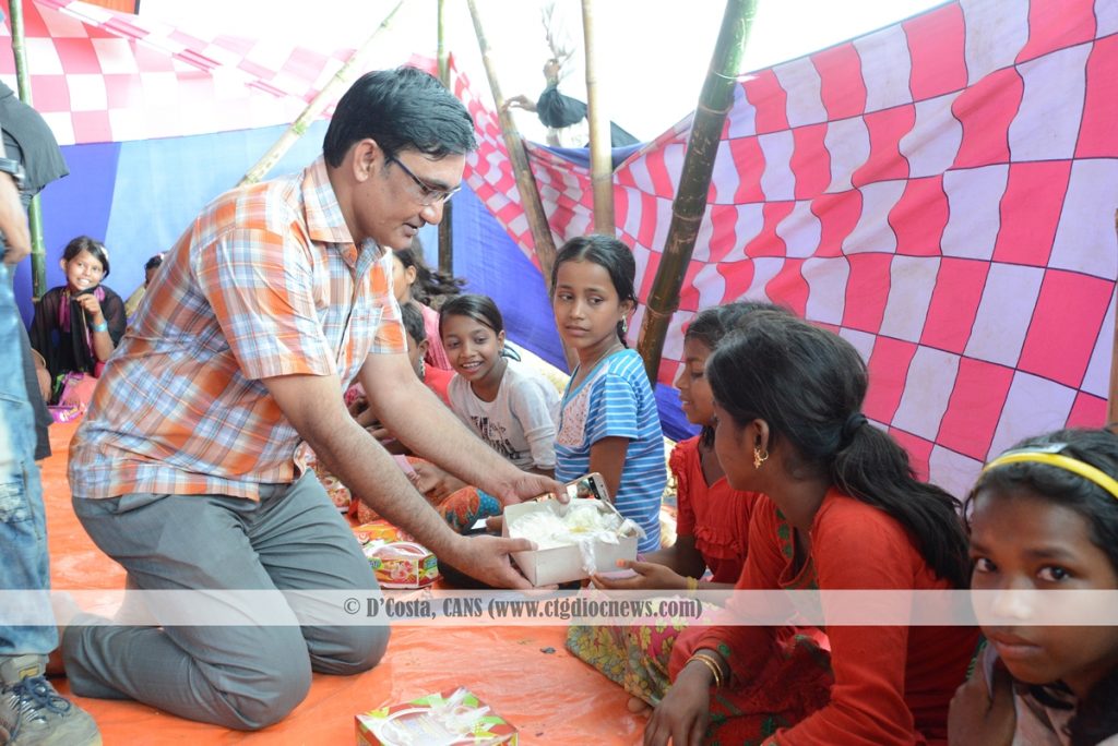 Regional Director of Caritas Chittagong James Gomes is sharing meal with a Rohingya Child
