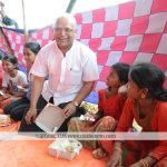 Bishop Lawrence S. Howlader CSC is sharing meal with a Rohingya Child